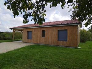 a small wooden house with a red roof at LE DOMAINE DES SENS - Chalet avec SPA privatif - pleine nature - expérience détente in Hans