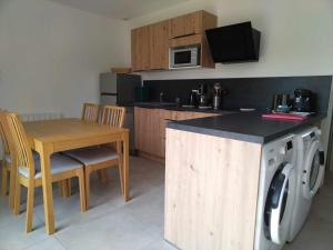 a kitchen with a table and a washing machine at LE DOMAINE DES SENS - Chalet avec SPA privatif - pleine nature - expérience détente in Hans