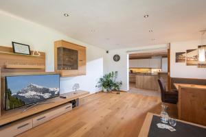 Una sala de estar con un televisor de pantalla plana grande. en Landhaus Kirchberg, en Kirchberg in Tirol