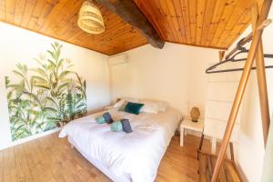 a bedroom with a white bed with blue pillows at Escapade en Val de Saône T4 familial & jardin in Thoissey