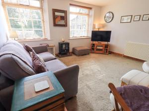 a living room with a couch and a tv at The Mounting Steps in Ambleside