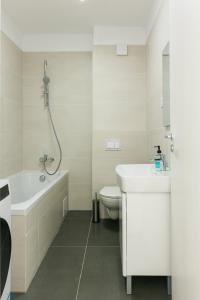 a bathroom with a tub and a sink and a toilet at Thirty Six Apartment in Bistriţa