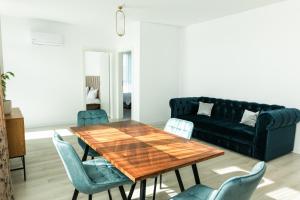 a living room with a table and a couch at Thirty Six Apartment in Bistriţa +7 photos