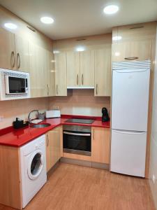 a kitchen with a white refrigerator and a dishwasher at VuT La Casita del Cuéntame in Burgos