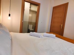 a bedroom with a white bed with two pillows on it at VuT La Casita del Cuéntame in Burgos