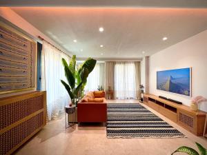 a living room with a couch and a flat screen tv at AARU Maadi Luxe Retreat in Cairo