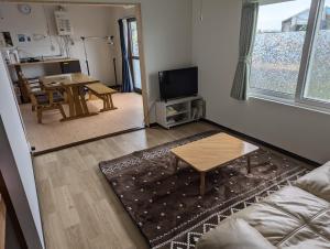 a living room with a couch and a table at 海辺の宿錦 b in Tomakomai