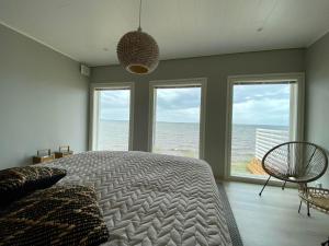 a bedroom with a bed and a view of the ocean at Beach House in Kalajoki