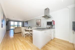 a kitchen and living room with a table and chairs at Ocean Surf - Luxury Apartment with Ocean Views in Lancelin