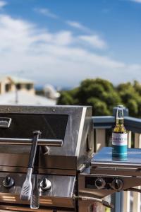a bottle of beer sitting on top of a grill at Sea Change - Spacious Family Holiday Accommodation Pet friendly in Ledge Point