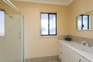 a bathroom with a sink and a shower at Sea Change - Spacious Family Holiday Accommodation Pet friendly in Ledge Point +13 photos