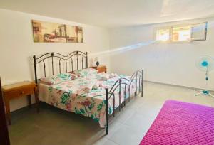 a bedroom with a bed and a pink rug at Mandorlo Barocco in Noto
