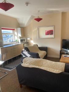 a living room with two couches and a kitchen at Aparthotel Blackpool in Blackpool
