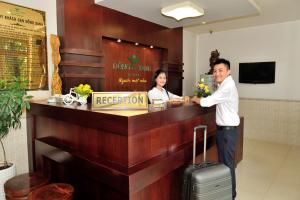 a man and a woman standing at a reception desk at Dong Xanh Hotel in Chau Doc