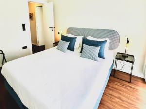 Un dormitorio con una gran cama blanca con almohadas azules. en NearTheSEA by YoursPorto, en Matosinhos 5 fotos más