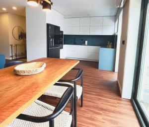 Una cocina con una mesa de madera y dos sillas. en NearTheSEA by YoursPorto, en Matosinhos