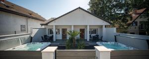 a house with a hot tub on a balcony at Balatonic Moon&Sun apartmanház in Siófok