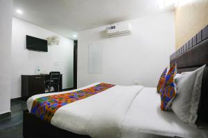 a bedroom with a large white bed and a desk at FabHotel NK Residency in New Delhi