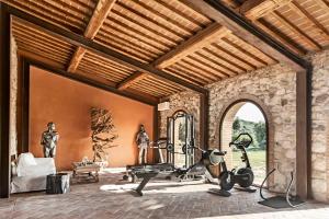 an indoor gym with exercise equipment in a house at La Pieve di San Giovanni Luxury Retreat & Spa in Lustignano