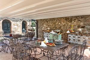 an outdoor patio with tables and chairs and a kitchen at La Pieve di San Giovanni Luxury Retreat & Spa in Lustignano