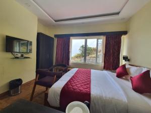 a hotel room with a large bed and a window at Hotel Jemvalley in Kodaikānāl