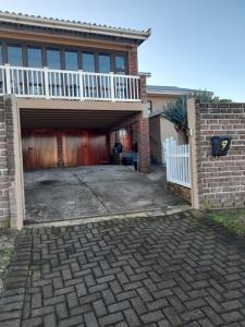 a house with a garage and a white fence at Breakers Edge in Bay View