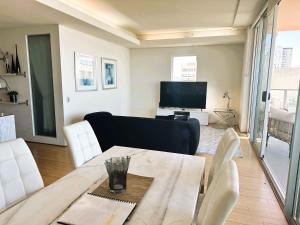パースにある114 Incredible Cbd Swanriver Suite Prkgのテーブルとソファとテレビのあるリビングルーム