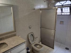 a bathroom with a toilet and a shower and a sink at Quarto Uberlandia in Uberlândia