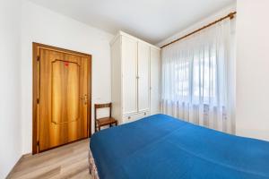 a bedroom with a blue bed and a wooden door at Casa Da Rin Emma in Auronzo di Cadore