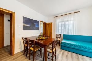 a dining room with a table and a blue couch at Casa Da Rin Giulia in Auronzo di Cadore