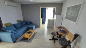 Una sala de estar con un sofá azul y una mesa. en Pomiculturii Residence 9, en Timisoara 8 fotos más