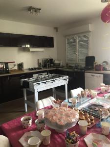 a kitchen with a table with food on it at Maison familiale entre Paris et Dysneland in Montreuil