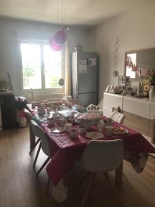 a dining room table with a purple table cloth at Maison familiale entre Paris et Dysneland in Montreuil