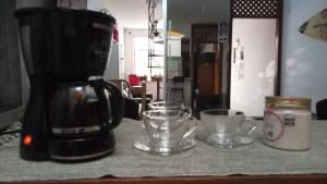 a coffee maker and two cups on a table at LiveRio Hostel Ipanema in Rio de Janeiro