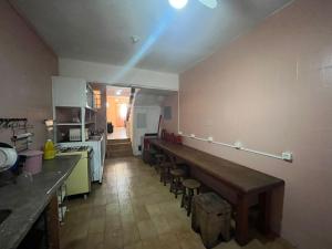 a kitchen with a long counter and chairs in it at LiveRio Hostel Ipanema in Rio de Janeiro
