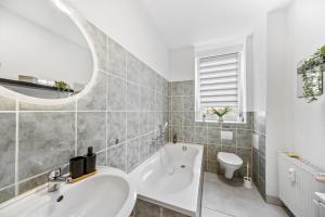 ハルバーシュタットにあるWohnung Stadtrand, 4 Personen, nahe Bahnhof und Seeの洗面台、浴槽、トイレを備えたバスルーム +16枚の写真