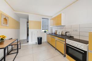 ハルバーシュタットにあるWohnung Stadtrand, 4 Personen, nahe Bahnhof und Seeのキッチン(黄色と白の電化製品、テーブル付)