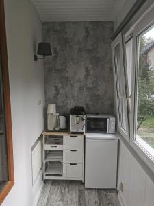 a small kitchen with a microwave and a stove at Pokoje gościnne Kamil 2 in Karpacz