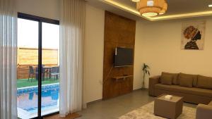 a living room with a couch and a tv at Cielo Beach Resort in Al Qaryah