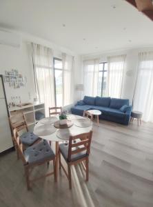 un salon avec une table et un canapé bleu dans l'établissement Ferienhaus Laura 70qm bis 5 Gäste mit Fass-Sauna, Whirlpool April bis Oktober, 75qm Terrasse und eingezäunten Garten Haustiere willkommen, à Sierosław