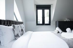 Domaine de Bracheux Luxury Lodges في بوفيه: غرفة نوم بيضاء مع سرير كبير ونافذة +33 صورة