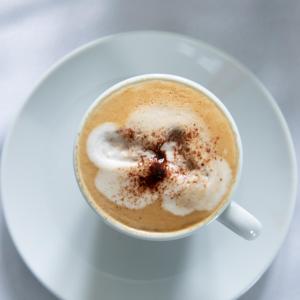 Domaine de Bracheux Luxury Lodges في بوفيه: كوب من القهوة على طبق ابيض