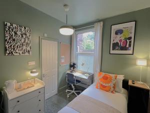 a bedroom with a bed and a desk and a sink at Melbury Rooms & Studios in Exeter