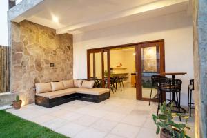 a patio with a couch and a stone wall at Pousada Cactus Jeri in Jericoacoara +25 photos