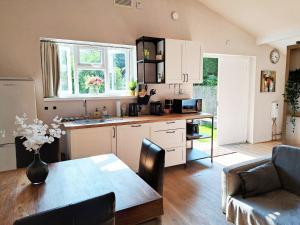 a kitchen and dining room with a table and a kitchen and a dining room at Charming Detached Cottage Near John Radcliffe Hospital Free Parking Self check-in in Oxford
