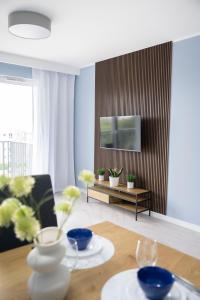 a living room with a table and a tv at Apartament Morski by GoApart in Gdańsk