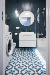 a bathroom with a sink and a washing machine at Apartament Morski by GoApart in Gdańsk