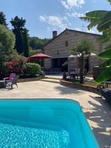 a blue swimming pool in front of a house at Toulousaine de 200 m2 10 pers Piscine proche de Toulouse in Lagrâce-Dieu