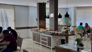 a group of people sitting at a table in a kitchen at Premier Pallace Hotel in Araguaína