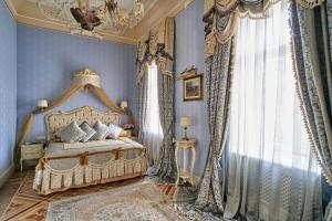 a bedroom with a canopy bed and a chandelier at Hotel Bristol in Odesa